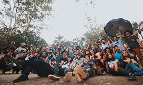 people from diverse ancestries smiling and giving peace signs at a meetup